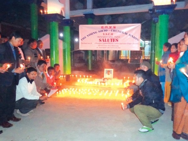 Candles being lit during a memorial service at Wahengbam Leikai Community Hall
