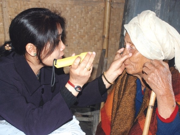 A lady doctor examining the eyes of an elderly woman during a free medical camp at  Lower Khoirentak