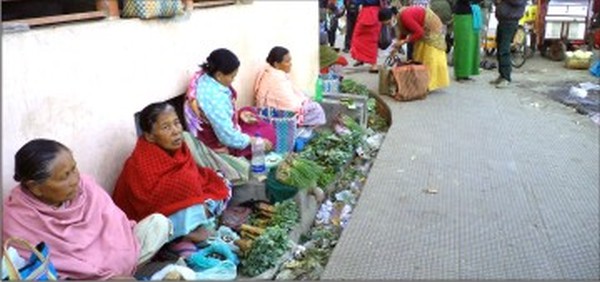Street vendors selling their wares just beyond the footpath at Khwairamband Keithel