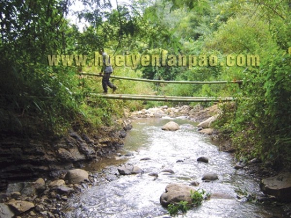 A villager crossing the bamboo bridge over Ronrei river