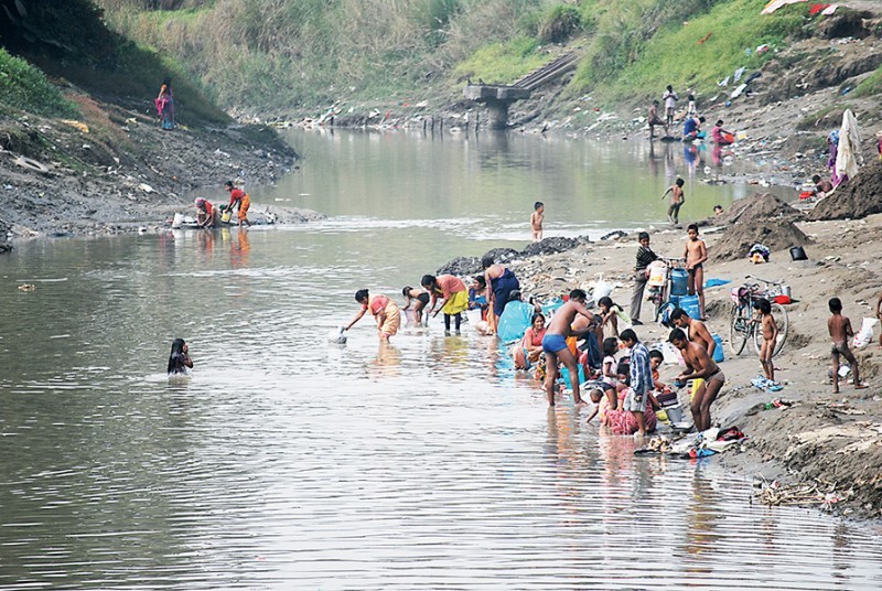 People washing and bathing in the water of Imphal River at Minuthong