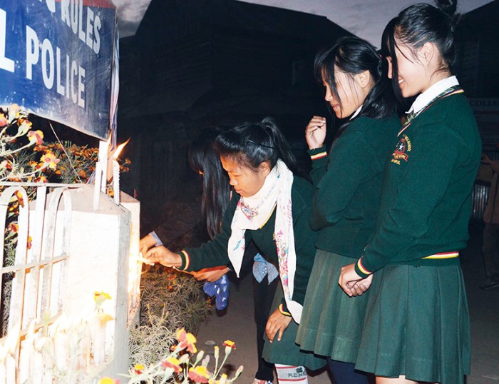 Students praying for peace at a candle light vigil organized by Tangkhul netizens at Gandhi Chowk in Ukhrul on Tuesday