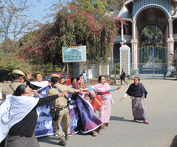 A police personnel tries to foil protest in front of Kangla Gate