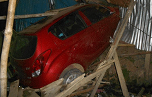 A picture of a car ramming into a house