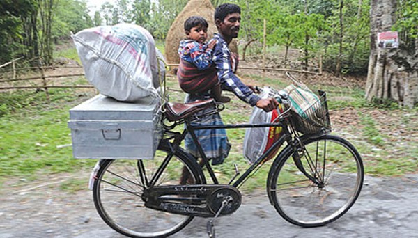 A villager flees with his child and belongings in trouble-torn Assam