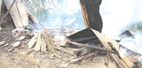 The burnt remains of the house of the murder suspect
