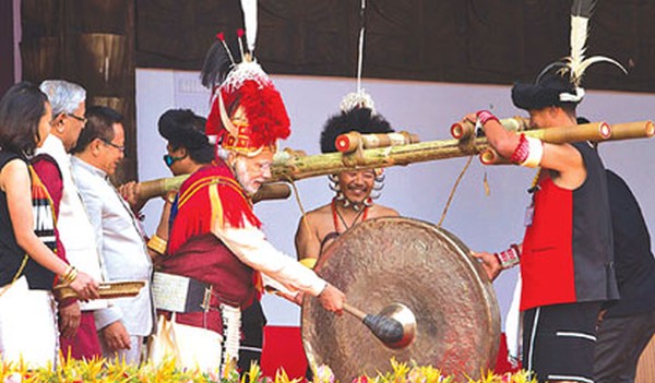 Prime Minister Narendra Modi, 3rd right, dressed in Naga attire hits a traditional musical instrument