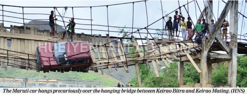 The Maruti car hangs precariously over the hanging bridge between Keirao Bitra and Keirao Mating