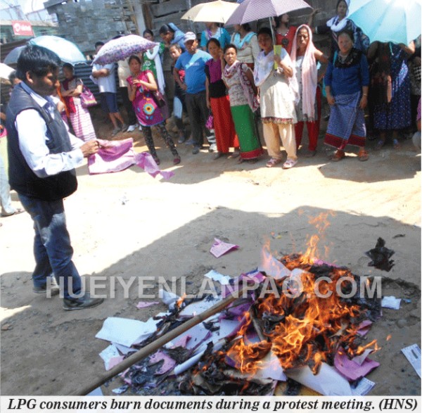 LPG consumers burn documents during a protest meeting