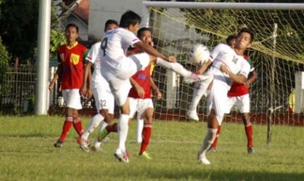 Players of YPHU (white) try to control the ball