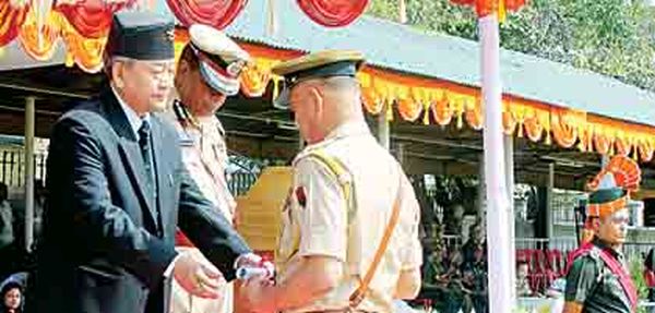 Gaikhangam giving away a commendation certificate to a cop