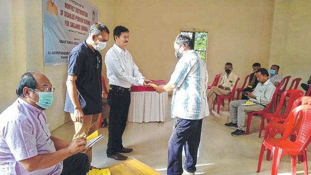 Social worker distributes pension to differently-abled persons