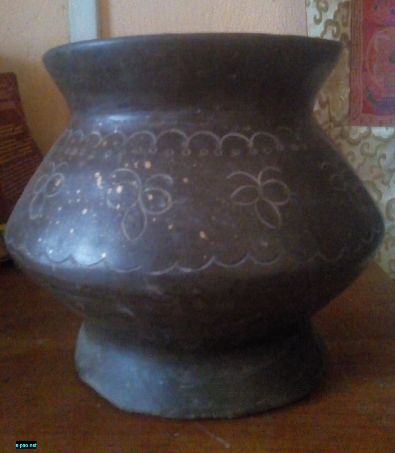 A mud-coloured pot with floral designs