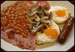   A typical cooked British breakfast with bacon, fried eggs, fried mushrooms, sausage and baked means 